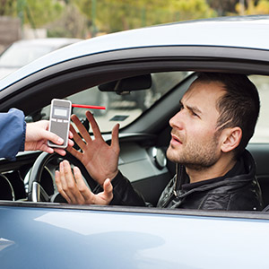 Driver refusing a breathalyzer test, illustrating a DWI arrest and refusal penalties in criminal law.